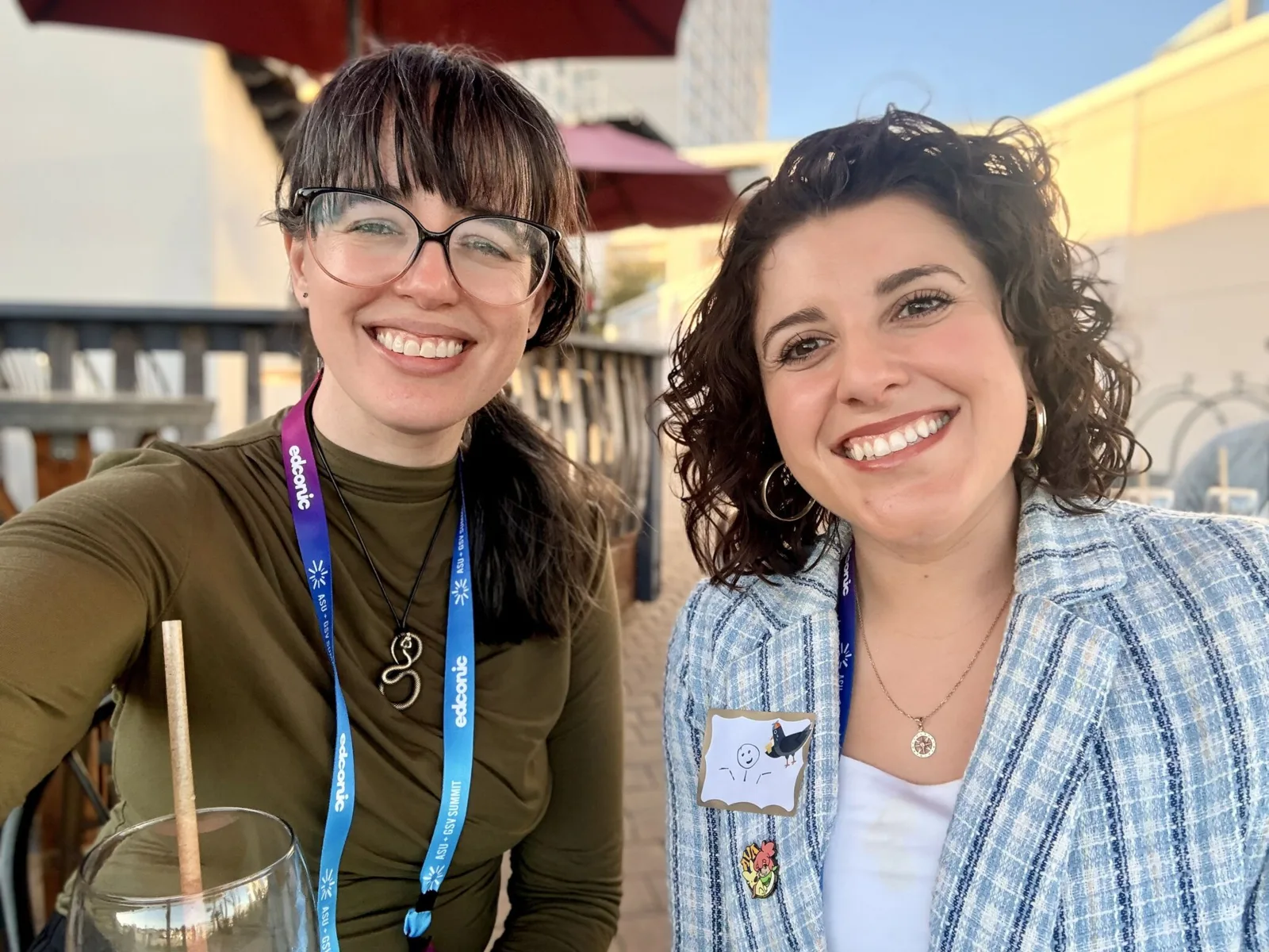 Lindsey with a peer at the conference, both smiling, lanyards on.
